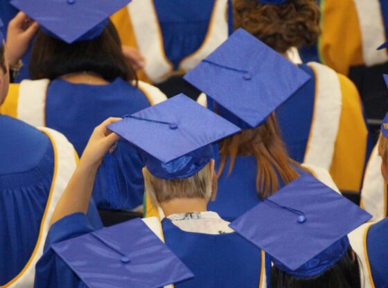 a tight close up shot of a student's blue graduation cap and gown